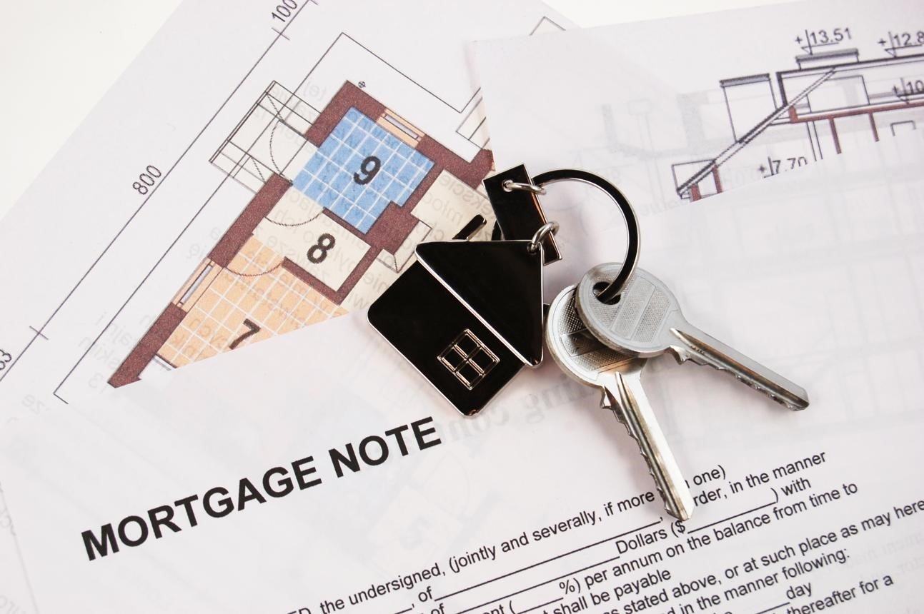 Mortgage documents and house keys illustrating real estate and estate planning after death